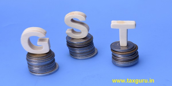 The word/abbreviation GST (Goods and services tax) on stack of coins over blue background